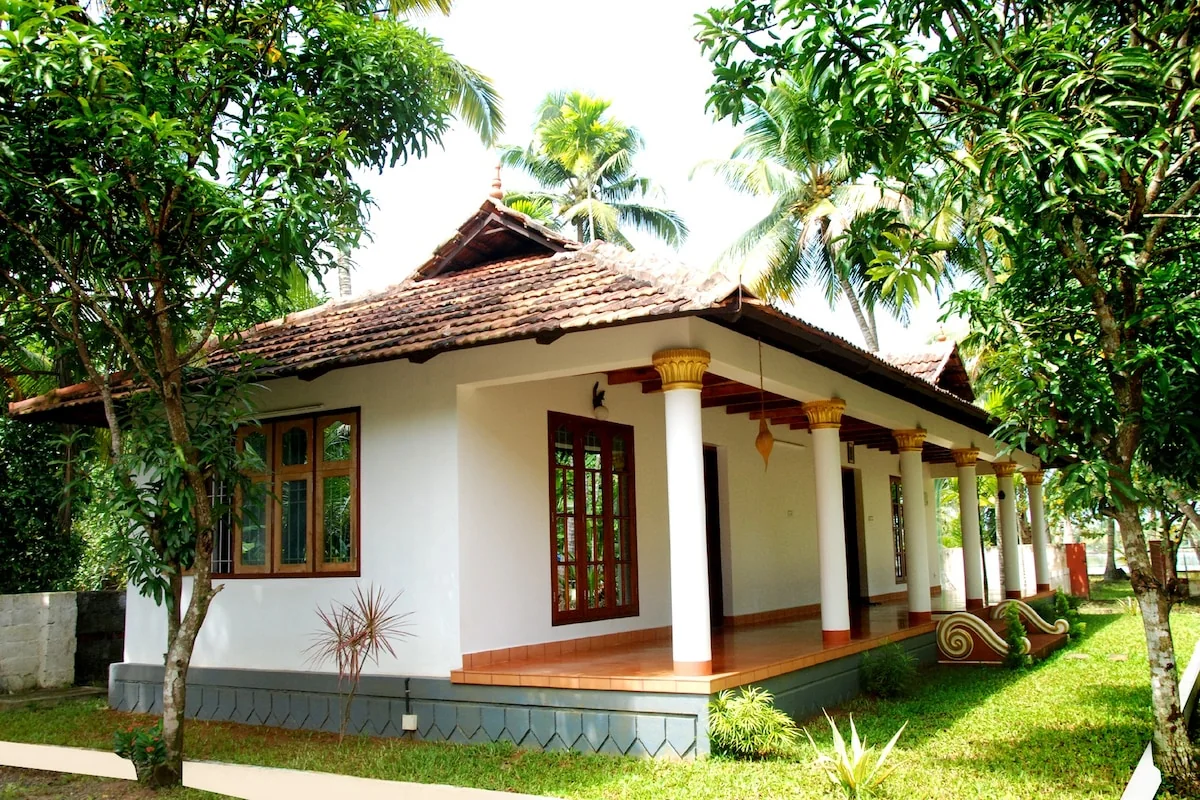 The homestay garden and traditional Kerala-style exterior.